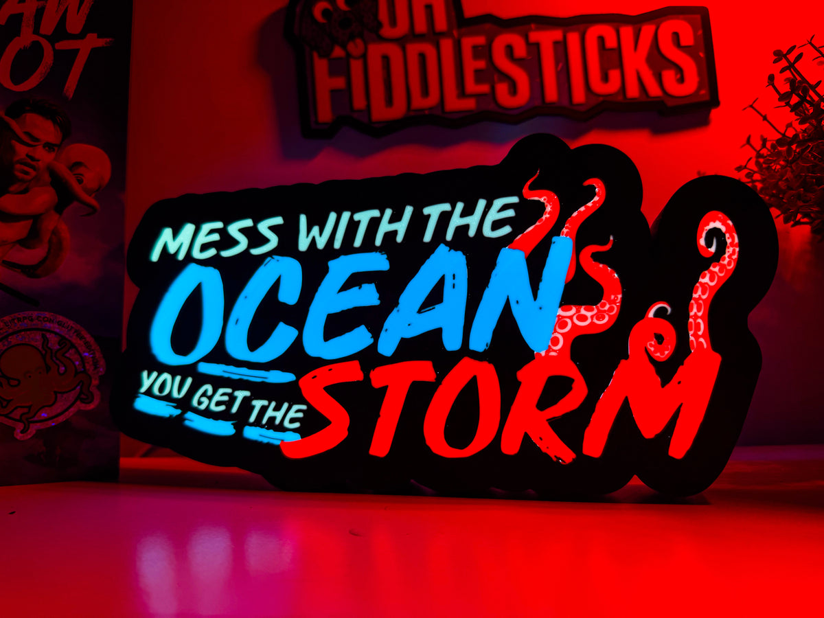 An LED lightbox and 3D signs glowing on a bookshelf beside a hardback.